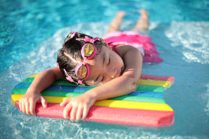 A young girl taking a break in a swimming pool...